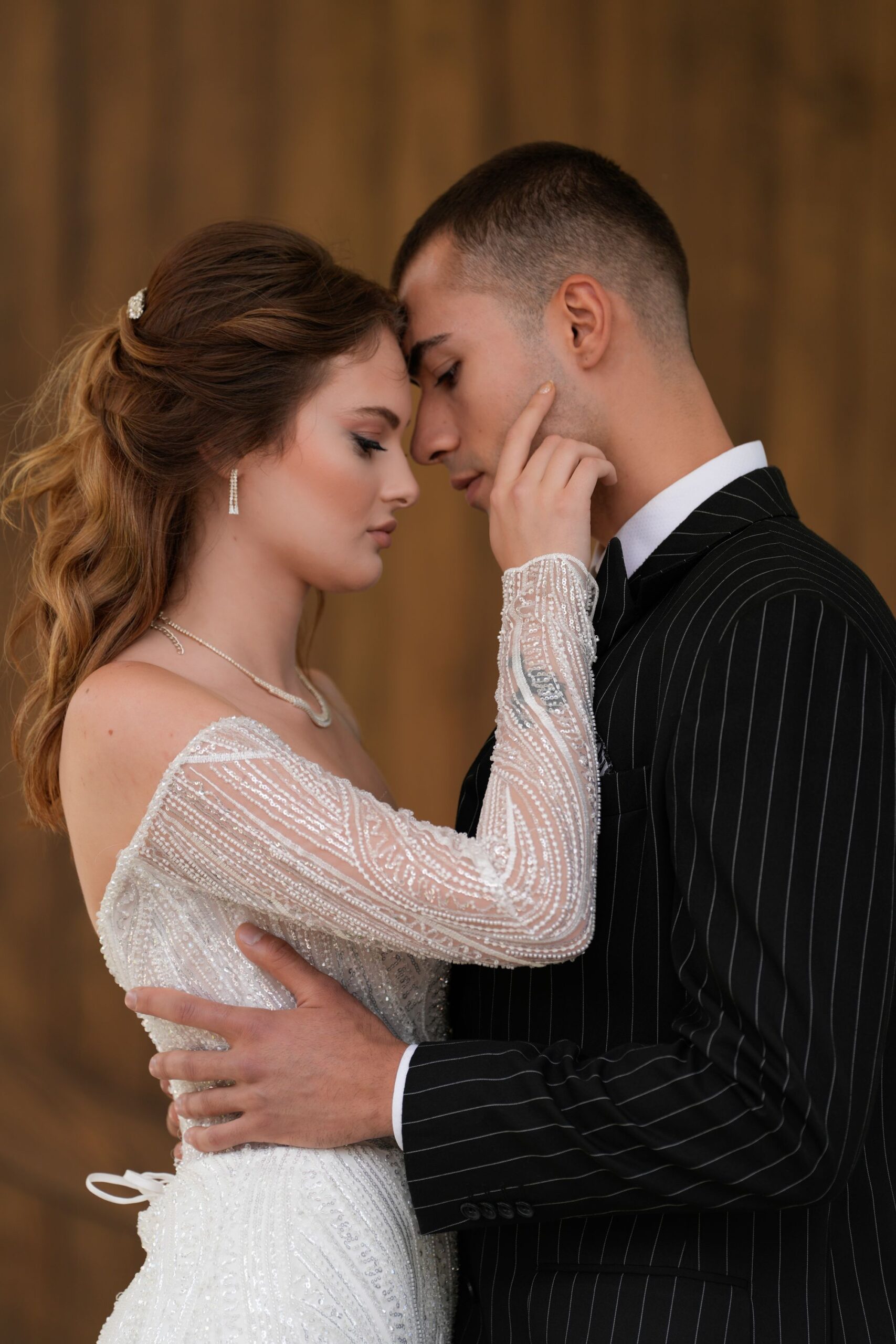 Bride and groom in formal attire sharing a tender moment