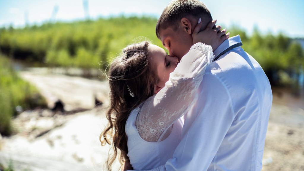 Couple sharing a tender kiss by a river on a bright day, intimacy that antidepressant sexual side effects can strain