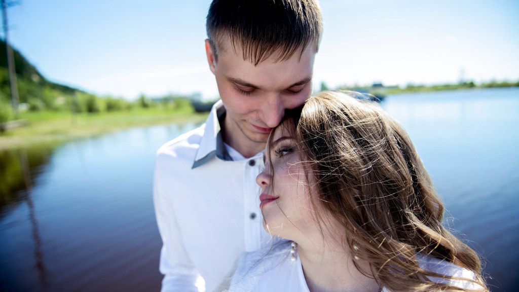 Couple embracing by a sunny lake, a picture of the closeness that a secure attachment style makes easier