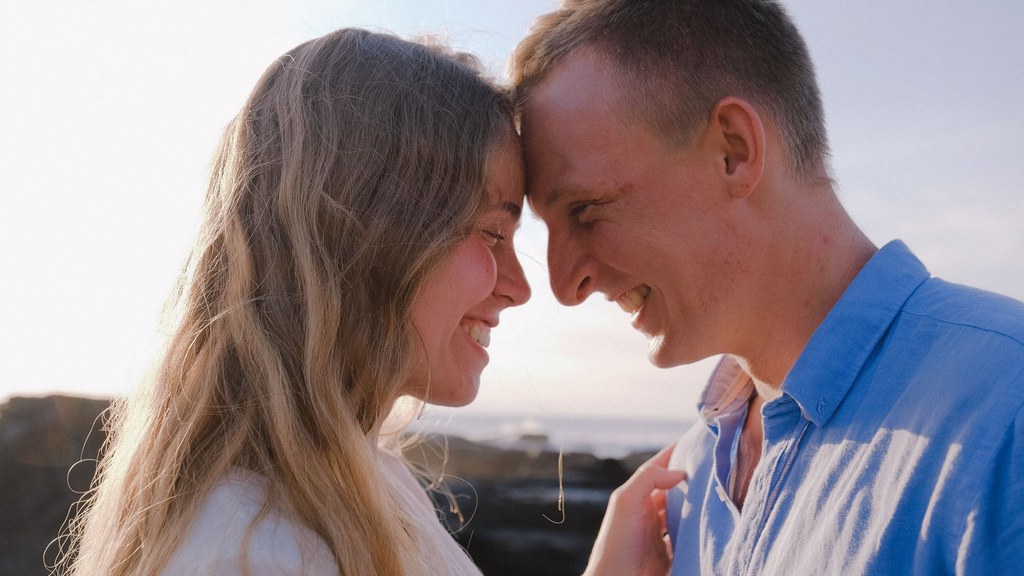 Couple touching foreheads and smiling in warm sunlight, a moment of trust behind better sex in marriage