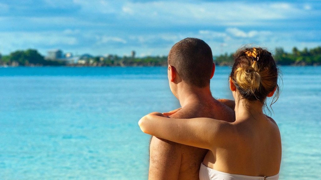 A couple embraces on a sunny tropical beach on their honeymoon, a closeness built on open sexual communication