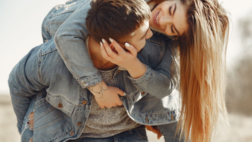 Laughing young couple outdoors; feeling understood is a sign of a good match