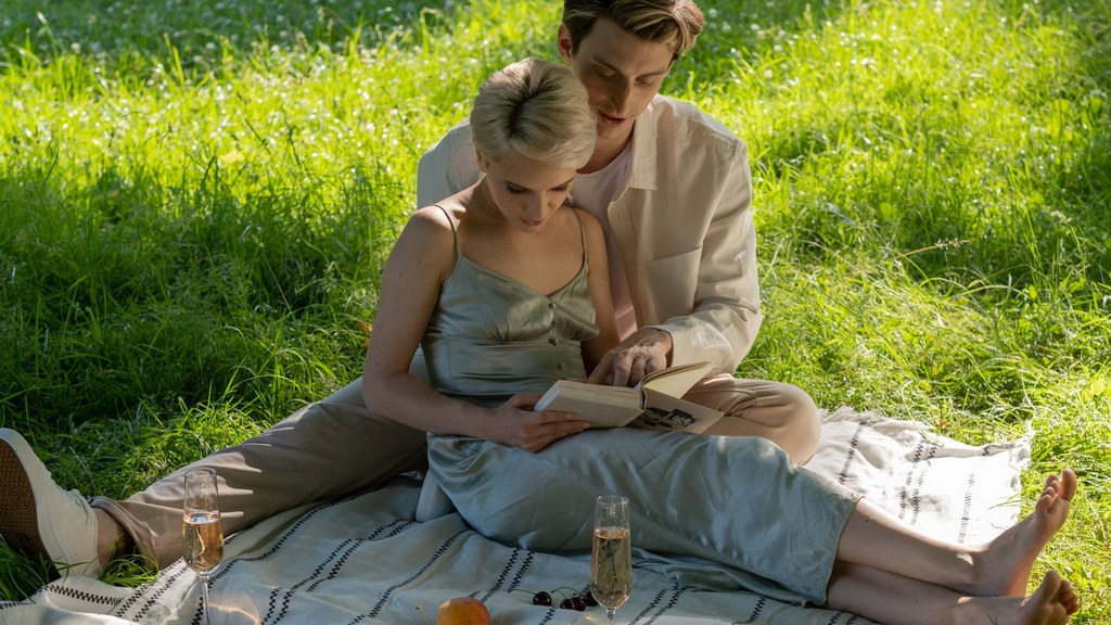 Couple relaxing close together on green grass at a sunny picnic, shared healthy habits that support liver health