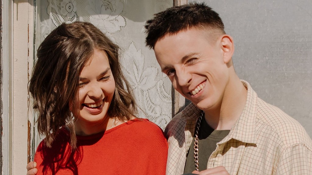 Smiling young couple side by side in the sun, a partner who sees your best self