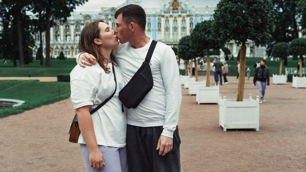 Young couple kissing in a sunny palace garden, a moment that asks whether this is the right person to marry