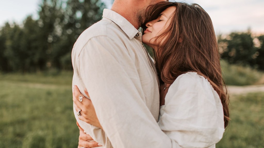 couple embracing in a sunlit field, showing how types of love share reward circuits